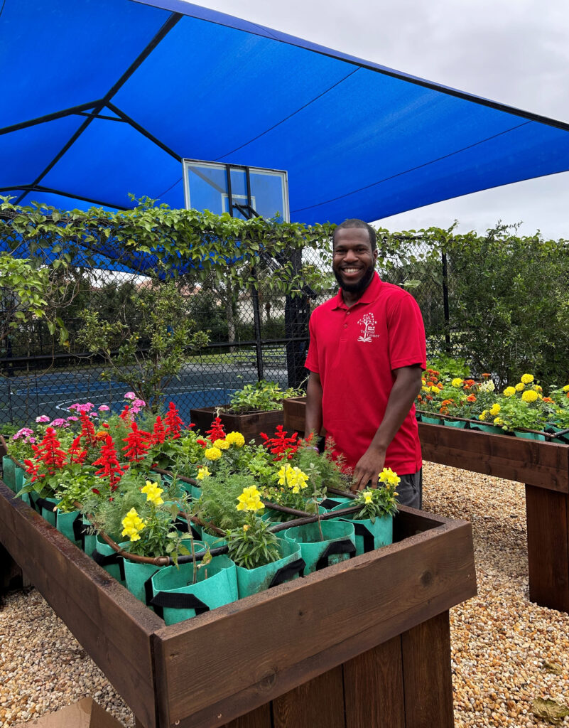 Jayvon Mobley in the community garden with the court’s shade sail in the background.